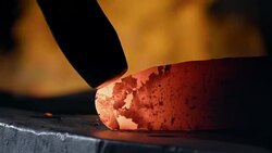 Heated steel is hammered into a blade shape with a hammer in a blacksmithing workshop. Stock Footage