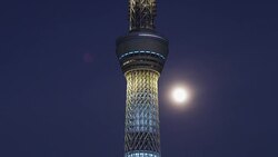 Illuminated Tokyo Skytree tower and full moon in the sky Stock Footage