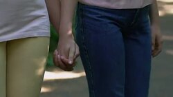 Two lesbians walking in park and holding hands secret meeting of same-sex couple Stock Footage