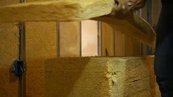 A contractor grabs a sheet of insulation for basement remodel - manly concept Stock Footage