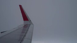 Airplane flight. Wing of an airplane flying above the clouds from window plane view Stock Footage