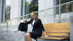 Happy businesswoman sits on bench, pleased with successful working day, rest Stock Footage