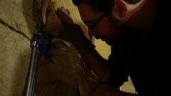 Electrician inspecting electrical lines in a box in unfinished basement Stock Footage