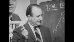 1960s: Man stands at chalkboard, talks, taps board Stock Footage