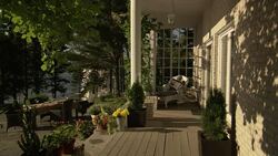 MEDIUM ANGLE OF OUTSIDE TERRACE OR PATIO. SEE BLACK PATIO FURNITURE ON LEFT. SEE STONE CONCRETE. SEE VASES OF PINK AND YELLOW  FLOWERS IN FOREGROUND. SEE MULTIPLE PINE TREES IN FOREGROUND. SEE CUMULUS CLOUDS IN BLUE SKY. SEE LAKE IN BACKGROUND. Stock Footage