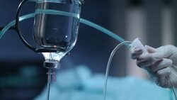 Gloved hands controling drop counter. Infusion bottle. Chemotherapy treatment Stock Footage