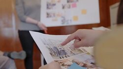 Creative designers discussing photograph proofs in meeting Stock Footage