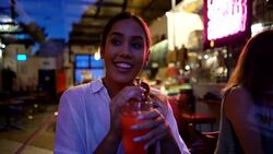 Beautiful mixed race young woman enjoying a juice at a cafeteria while looking away pensive but happy Stock Footage