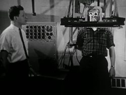 965: Man stands in vision measuring device, scientist measuring subjects reactions Instructional Video