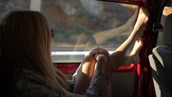 A young redhead woman enjoys traveling by car throws her legs on the window. Stock Footage
