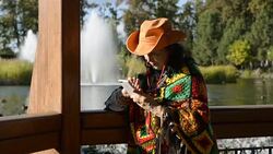 Adult stylish woman in a stylish cowboy hat and a multi colored poncho. Stock Footage