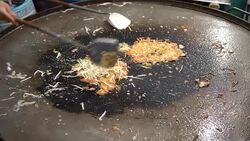 4k Cooking mussel fried in egg batter in hot flat pan Stock Footage