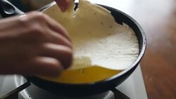Putting thin pancake on frying egg, 4k Stock Footage