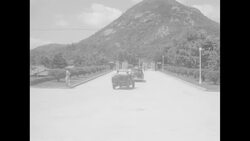 MPs, jeeps and cars drive up tree-lined Seoul street on day that Gen. Mark Clark, Commander of UN Forces, visits the city News Clip