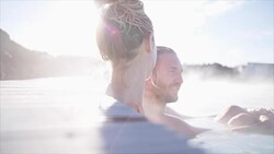 Geothermal spa. Young couple relaxing in hot spring pool in Iceland. people enjoying bathing in a blue water lagoon Icelandic tourist attraction, Video SLOW MOTION Stock Footage