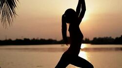 Women are practicing yoga in the park with evening light Stock Footage