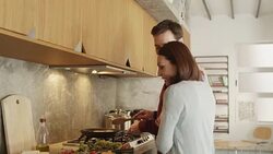 Smiling man embracing woman while cooking food Stock Footage