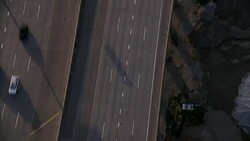 AERIAL BIRDSEYE POV OF CARS DRIVING ON SAN FRANCISCO INTERSTATE FREEWAY. CAMERA TRACKS FREEWAY AS IT CURVES LEFT AND SPLITS OFF TO EXIT. Stock Footage