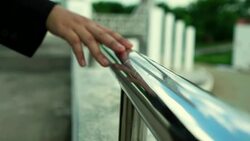 Slow Motion: Woman walking and holding hands with an iron railing relaxed mood Stock Footage