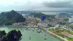 4k Aerial view over city and park with Bai Tho karst mountain Ha long bay. Halong City. Stock Footage