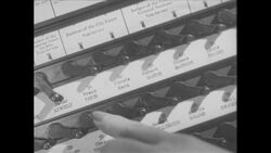 1960s: Man walks into voting booth, closes curtain behind him, flips switches on voting machine Stock Footage