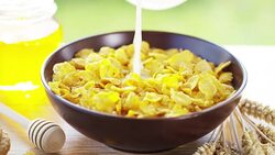 on a sunny day in the garden pours cereals in a cup where the cereals falls in slow motion . concept of healthy food and breakfast of milk and bisquits or cookies and cereals. bio food Stock Footage
