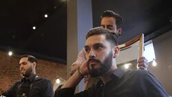Man examining his new look after haircut in salon Stock Footage