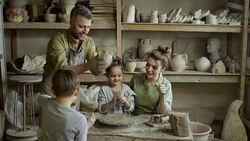 Family of Four Making Pottery in Workshop Stock Footage