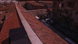 HIGH ANGLE DOWN OF SPANISH TILE ROOFTOPS IN LOWER CLASS RESIDENTIAL AREA. EUROPEAN CITY. Stock Footage
