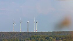 Wind turbines and agricultural fields on a summer day Stock Footage