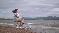 Young woman playing with her cat by the lake. Stock Footage