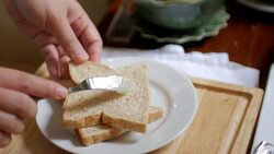 Spreading butter on a slice of bread for breakfast Stock Footage