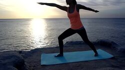 Young beautiful woman practicing yoga next to the see while looking at a beautiful sunrise Stock Footage