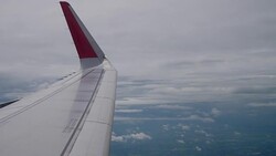Airplane flight. Wing of an airplane flying above the clouds from window plane view Stock Footage