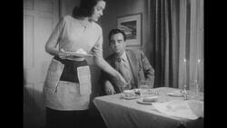 1950s: Wife brings plates of food from the kitchen and shuts door Stock Footage