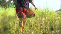 A young woman is spinning in a meadow in a dress. Stock Footage