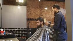 Barber trimming client's hair using electric razor Stock Footage