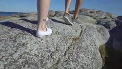 People walk among the coastal stones in Tjome nature Park, Norway Stock Footage