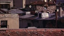 WIDE ANGLE OF LOWER CLASS RESIDENTIAL AREA IN EUROPEAN CITY. SPANISH TILE AND CORRUGATED METAL ROOFTOPS. Stock Footage