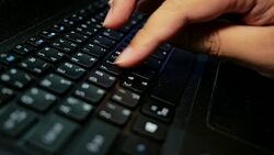 Close-up of a man's hand typing letters on a laptop computer's keyboard with soft focus scene. Stock Footage