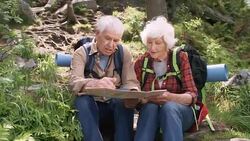 Elderly Hikers Checking Route on Map in Forest Stock Footage