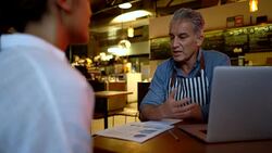 Business owner of a small bakery talking to a new female hire looking very focused Stock Footage