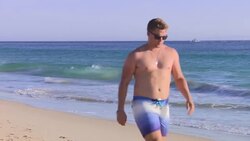 Tourist walking along the sandy Atlanterra Beach News Clip