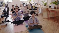 Serene creative business people meditating in office Stock Footage