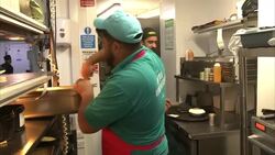 Chefs preparing curries and other dishes in restaurant kitchen News Clip