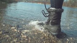 LOW ANGLE: Unrecognizable woman in furry boots running in the tranquil stream. Stock Footage
