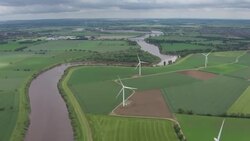 The River Ouse surrounded by green countryside and wind turbines News Clip