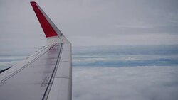 Airplane flight. Wing of an airplane flying above the clouds from window plane view Stock Footage