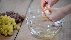 Woman hands breaking an egg to separate egg white and yolks and egg shells at the background. Stock Footage