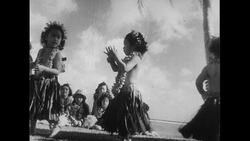 Hawaii, 1952: Three girls hula dance as music plays and people partake in a luau Stock Footage